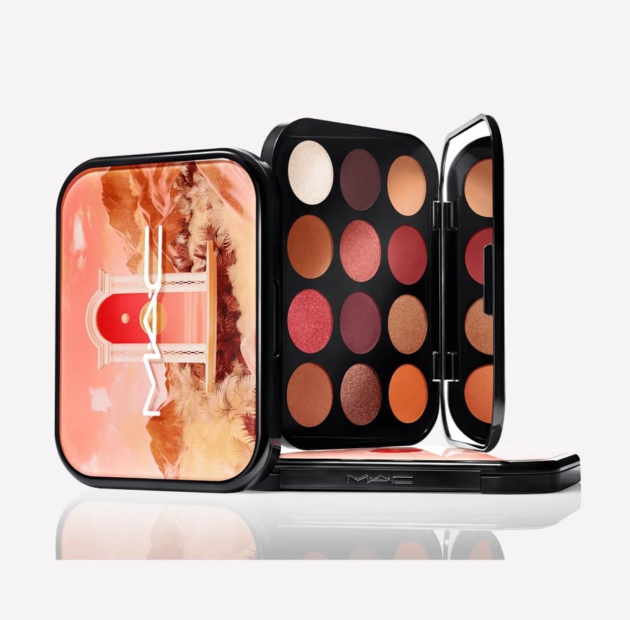 Eyeshadow palette posed vertically on white background. There are twelve pressed powder eyeshadow pans in a range of golden yellows, oranges, reds, and burgundies, with one bright highlight color in a warm off-white.