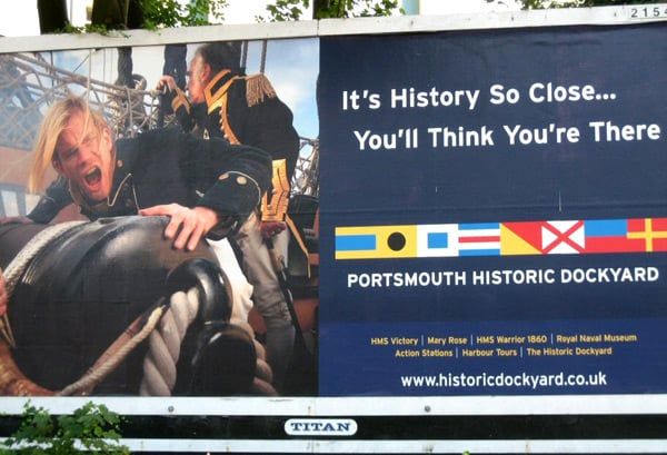 An advert for the naval base in Portsmouth, UK, showing what appears to be a sailor of antiquity receiving something from a sailor behind him.