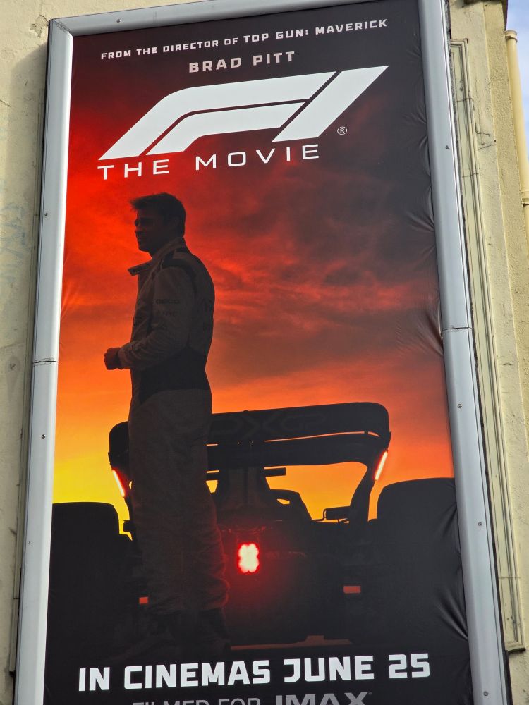 A poster for F1 the movie but the lettering of F1 are unreadable gibberish , so it looks like Brad Pitt The Movie!