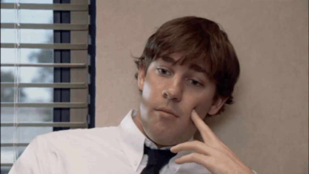 a man in a white shirt and black tie is looking out a window