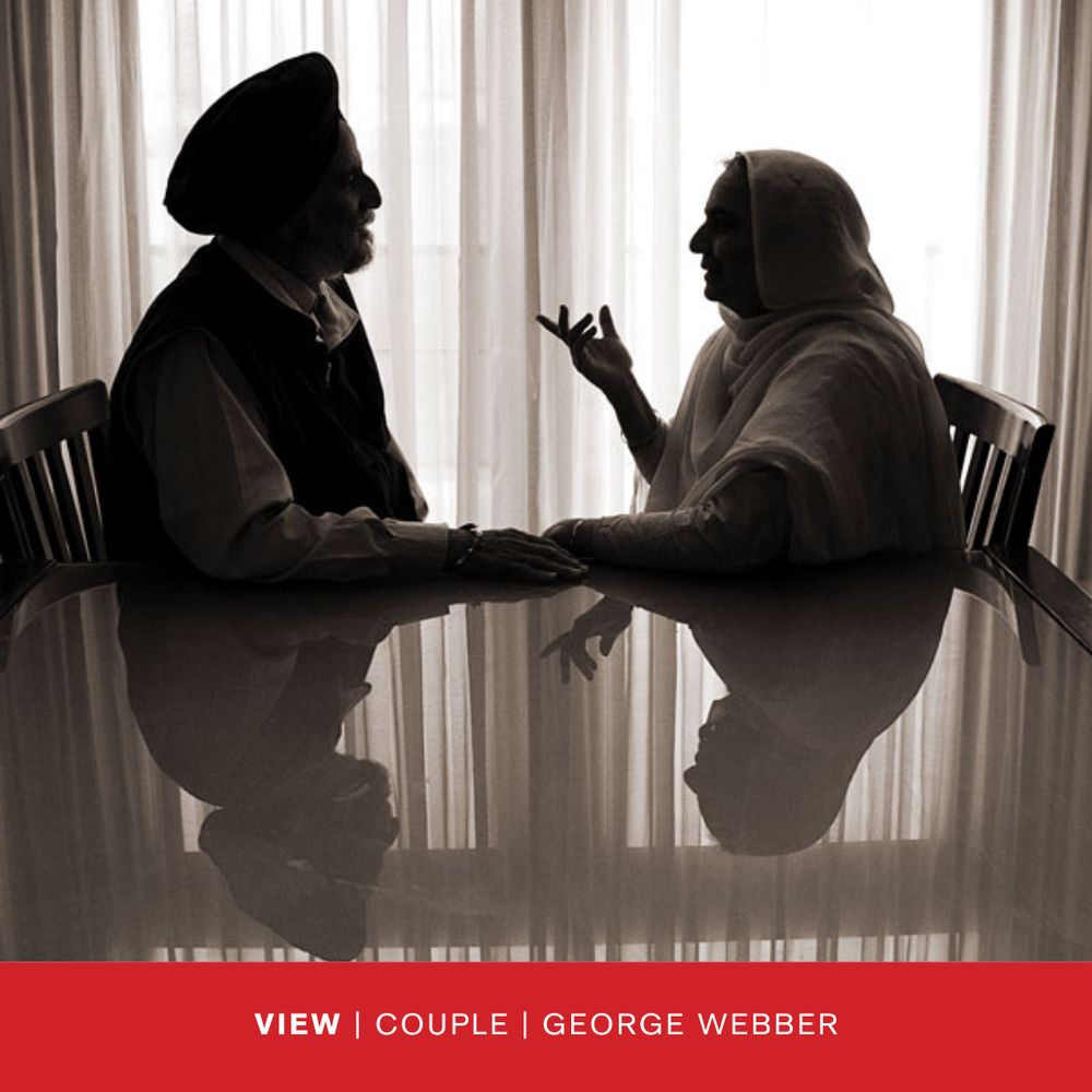 A photograph of two people sitting at a table having an intimate conversation. by George Webber