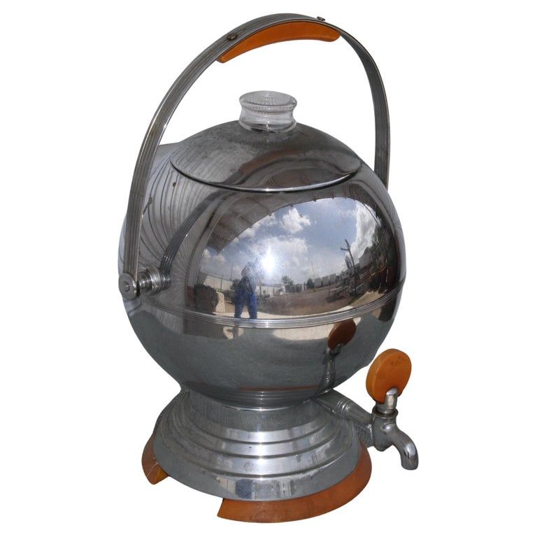 A vintage 30's coffee maker orb. Spherical metal pot with bail handle, spout and bakelite detailing. A clear knob protrudes from the top. Probably it shows coffee when the orb is percolating. 