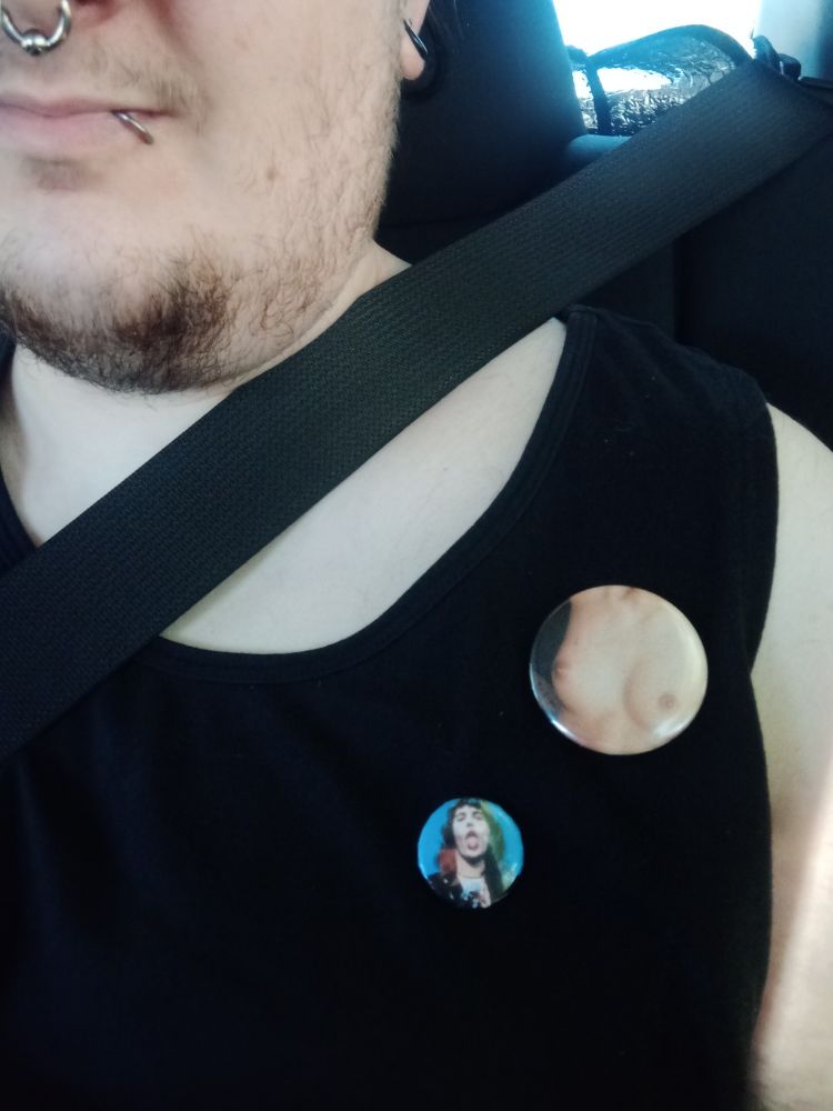 a pin of a pair of breasts, and a pin of Freddie Mercury sticking his tongue out.