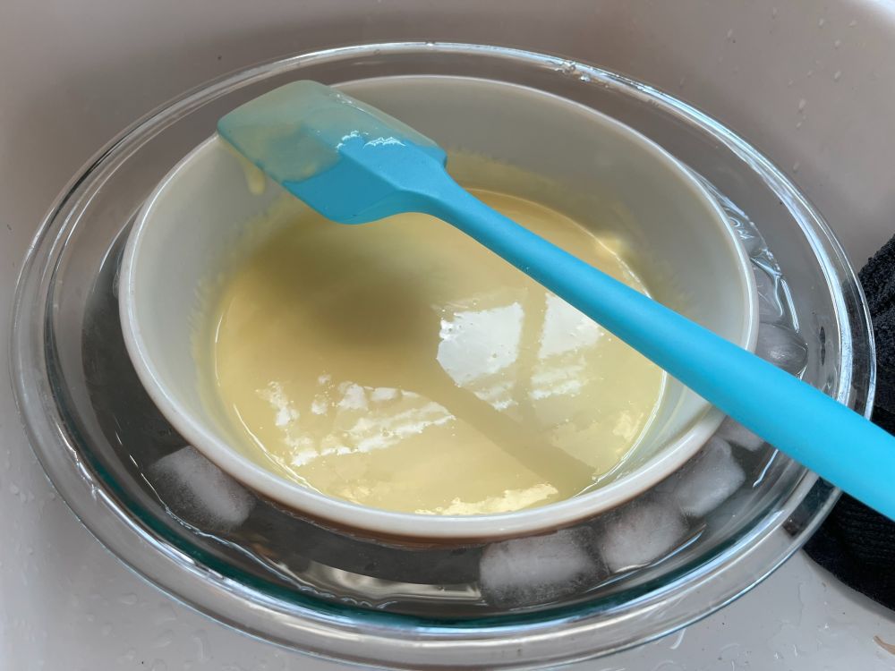 A bowl of vanilla custard ice cream base chilling in an ice bath