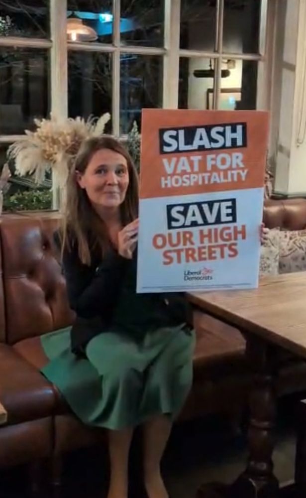 Vikki in Lambs Green pub Corfe Mullen with campaign board to slash bat and save the high street 