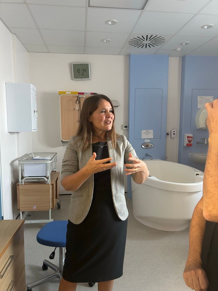 Vikki discussing issues with the delivery team. Baby cot and birth pool are in the background 
