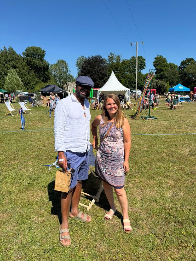 Vikki and Cllr Will with stalls behind on the village paddock 