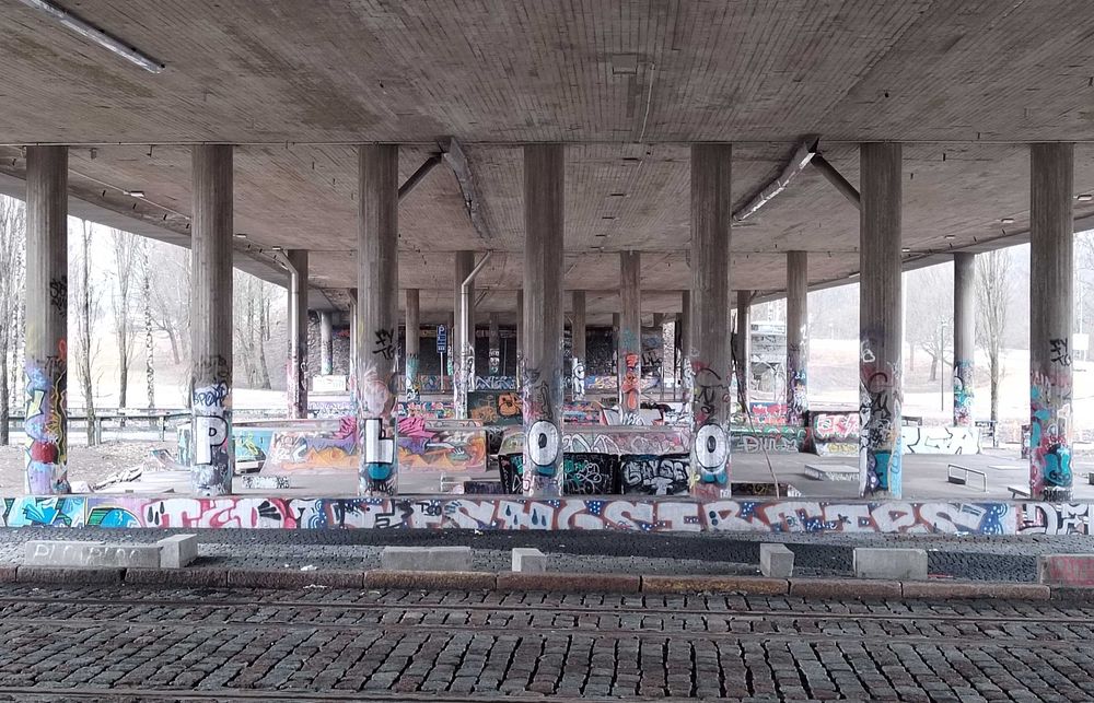 Skeittiparkki betonisen sillan alla, pylväissä ja korokkeissa useita värikkäitä graffiteja.
