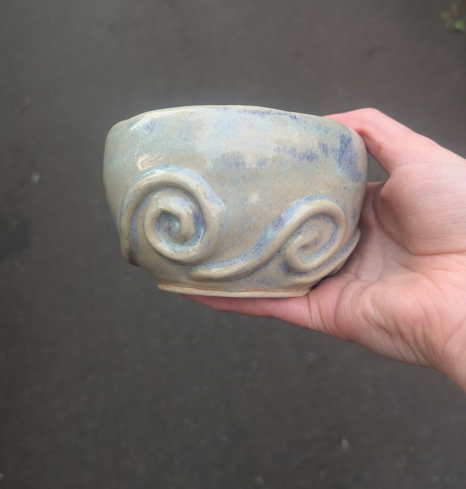 mug from a different angle with two swirls on it it's light blue. 
