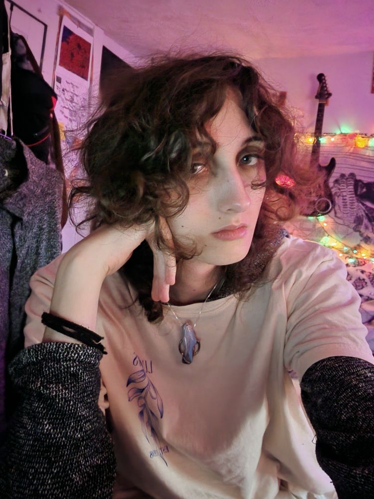 casval lour at home sitting at her desk in her sister's tee-shirt over her grey hooded shawl looking tired but sweet