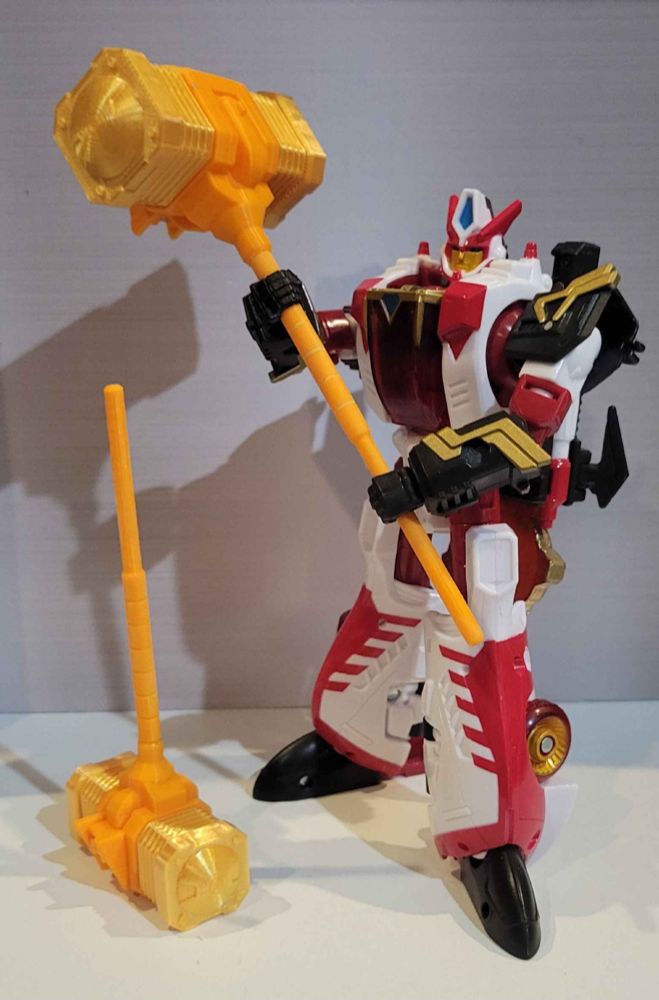 Legends Override holding a Goldion Hammer. A smaller version sits next to her.