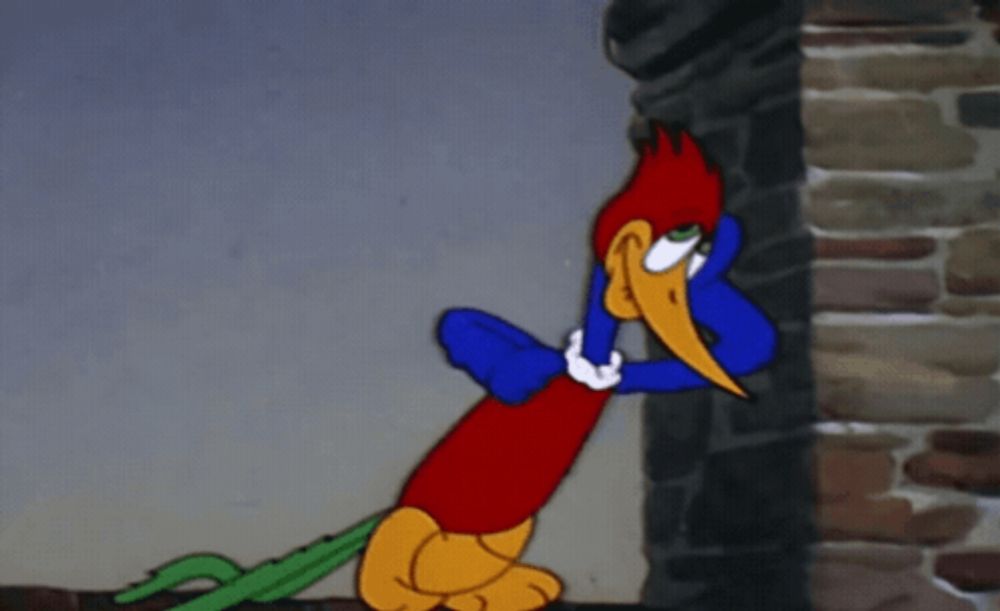 woody woodpecker is standing next to a stone wall