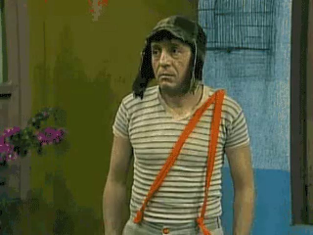 a man wearing a helmet and suspenders is standing in front of a wall