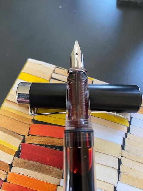 Close-up of PenBBS 494 demonstrator fountain pen holding Diamine Oxblood ink, on a copy of the 2022 Best American Short Stories.