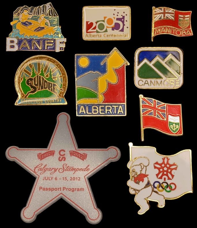 Transparent lapel pins in a collage format. From top left to bottom right:
A Banff pin with two people on a yellow raft backdropped by mountains
The 2005 Alberta Centennial logo
The Manitoba flag
A round pin with a setting sun behind tall pine trees, and a bison in the foreground stylized with the word Sundre. At the bottom it reads greenwood country
A minimalist blocky red and yellow grain elevator with a noon sun, a simplistic rocky mountain skyline and the praries all in saturated colours. It reads Alberta at the bottom.
A minimalist logo with the three sisters mountains, it reads Canmore at the bottom.
A large pin shaped like a sheriff's star, reading Calgary Stampede Passport Program.
The 1988 Olympics mascot Howdy holding a flag and running while smiling. The flag has the Olympic rings and the Calgary winter games logo