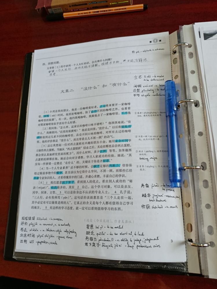 a photo of a printed text in mandarin. the sheet of paper is full of vocabulary notes and highlighted words.