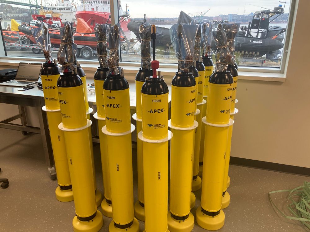 14 Teledyne Webb APEX Argo floats set up in a lab for testing at the Bedford Institute of Oceanography in Halifax, Canada. 7 of them have an SBE CTD, and the other 7 have the new RBRArgo CTD (red).