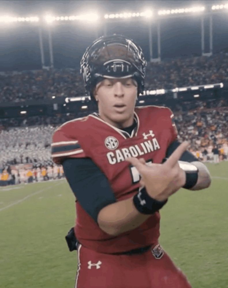 a football player wearing a carolina jersey is making a funny face