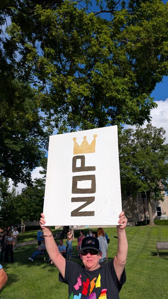 Person holding protest sign that says NOPE where the E is shaped like a crown for No Kings June 14 2025.