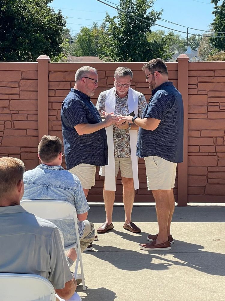 Two men marrying each other with a Disciples of Christ pastor officiating.