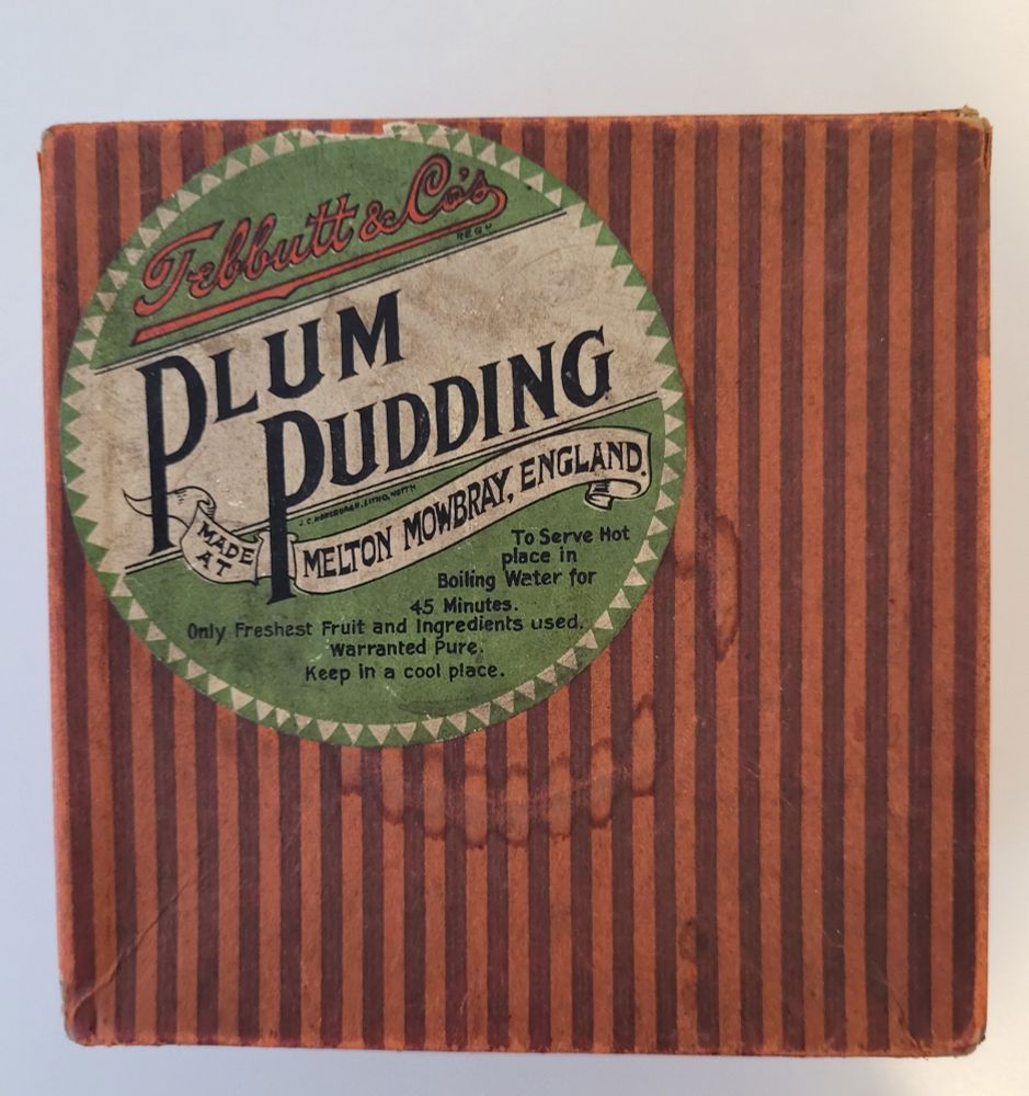 The lid of an old plum pudding box - red stripes with a green label.