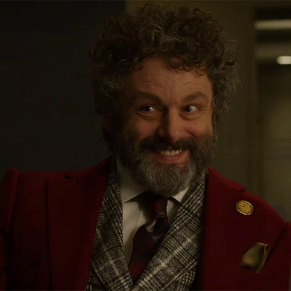 a man with curly hair and a beard is wearing a red jacket