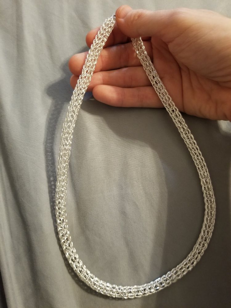A simple silver necklace made with a wire-weave technique.