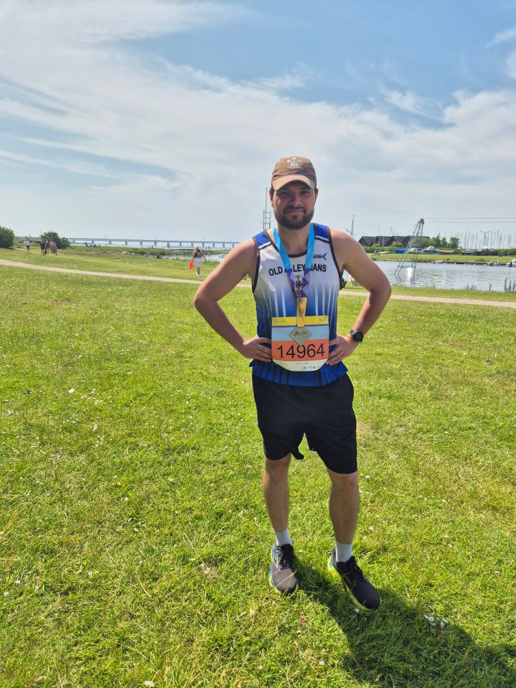 Chris smiling and wearing his race number after the Bridge Run 2025