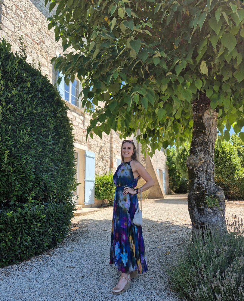 Sian standing smiling next to a tree