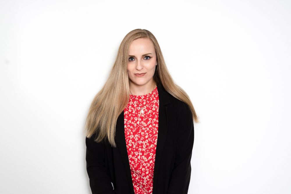 Headshot of Sian Elvin smiling, wearing a red top and black blazer