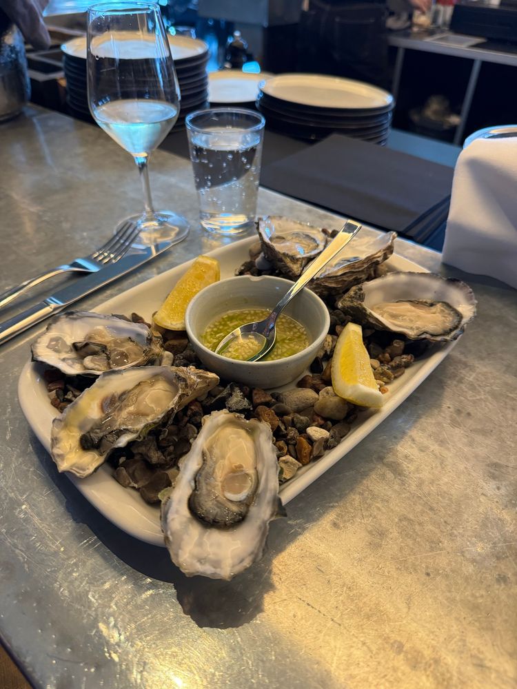 A photo of a plate of six oysters