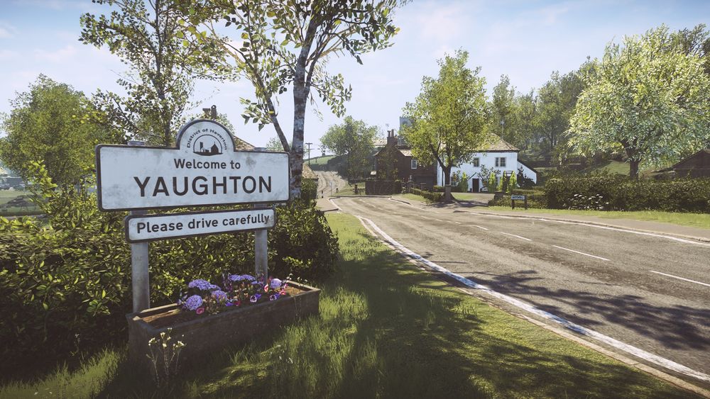A screenshot from the game Everybody's Gone to the Rapture showing a road passing through an English village with a sign on the left reading "Welcome to Yaughton, please drive carefully"