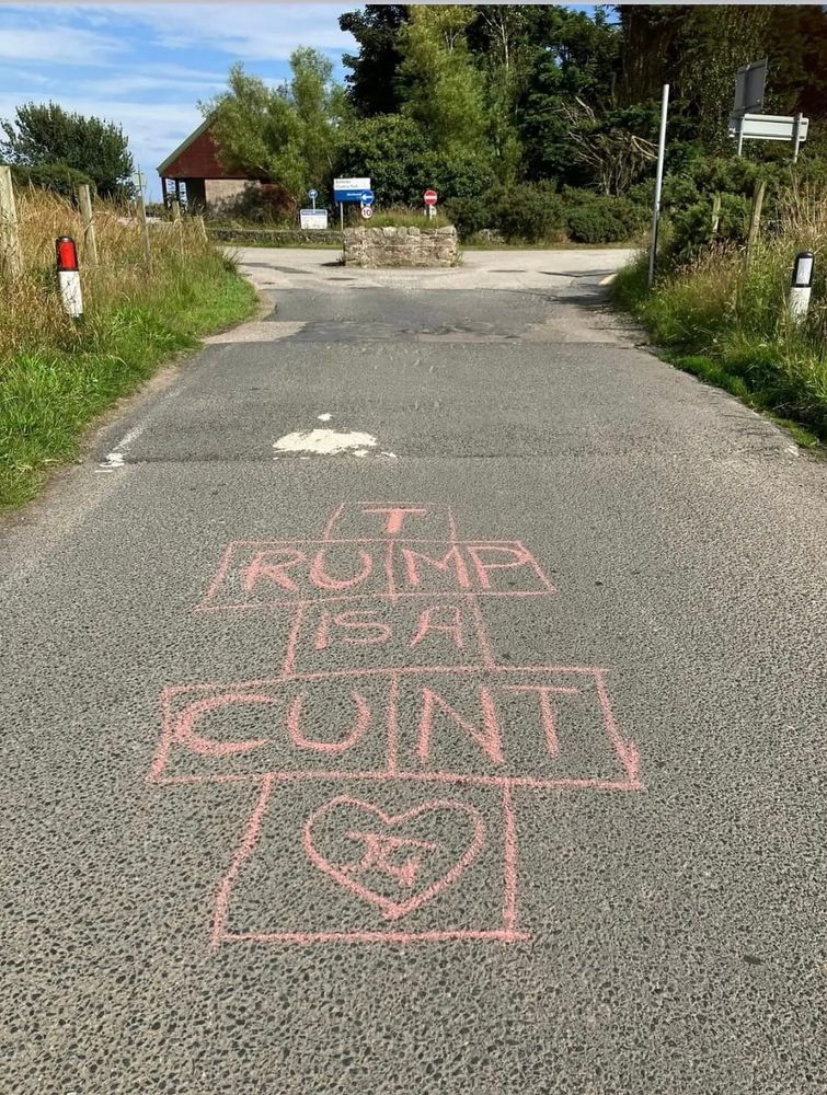 Chalk written on the road says Trump is a cunt