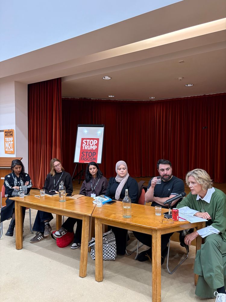 Panellists sit at a table.