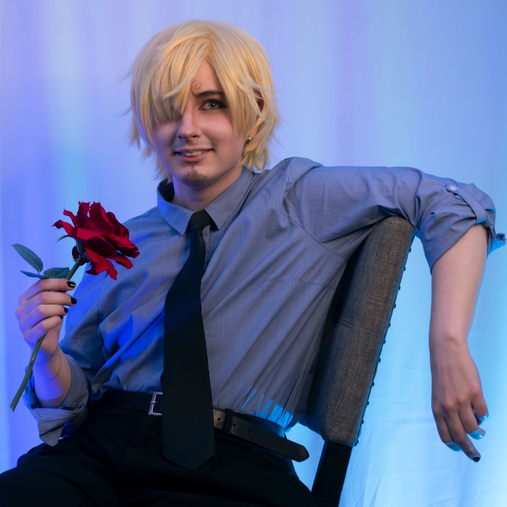 Cosplay of sanji from one piece sitting in a chair holding a rose