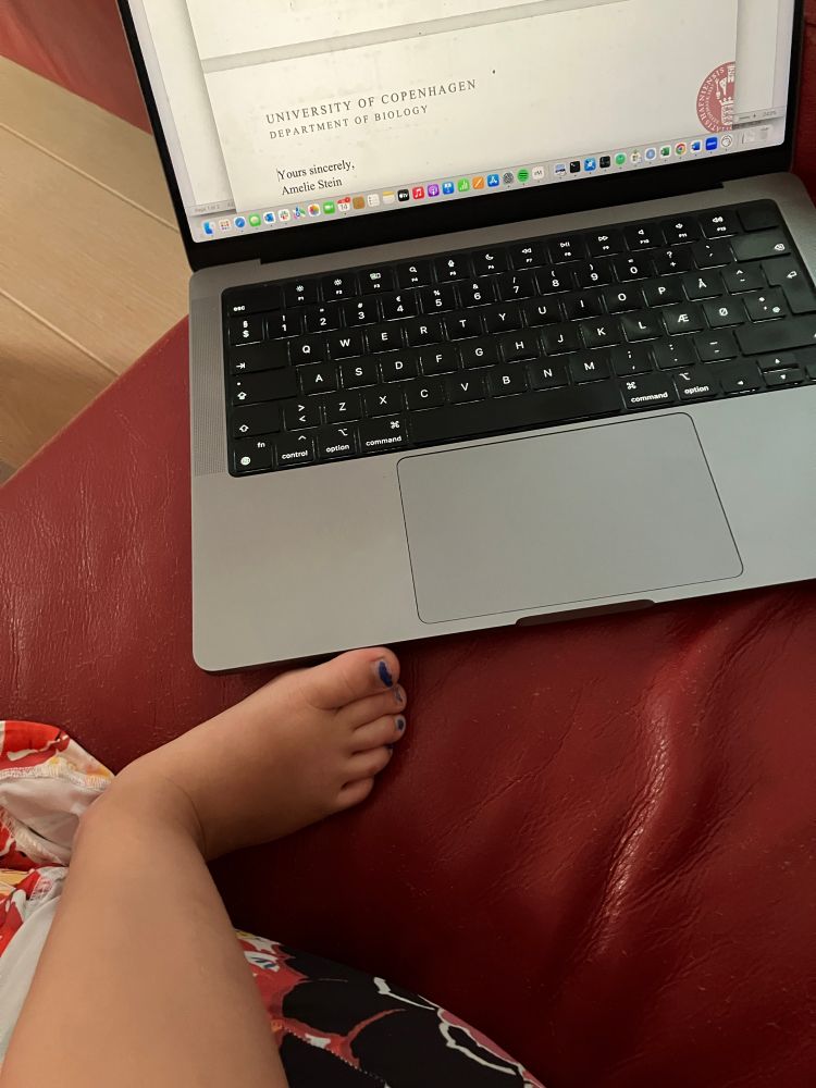 Leg and foot of a small child next to open laptop 