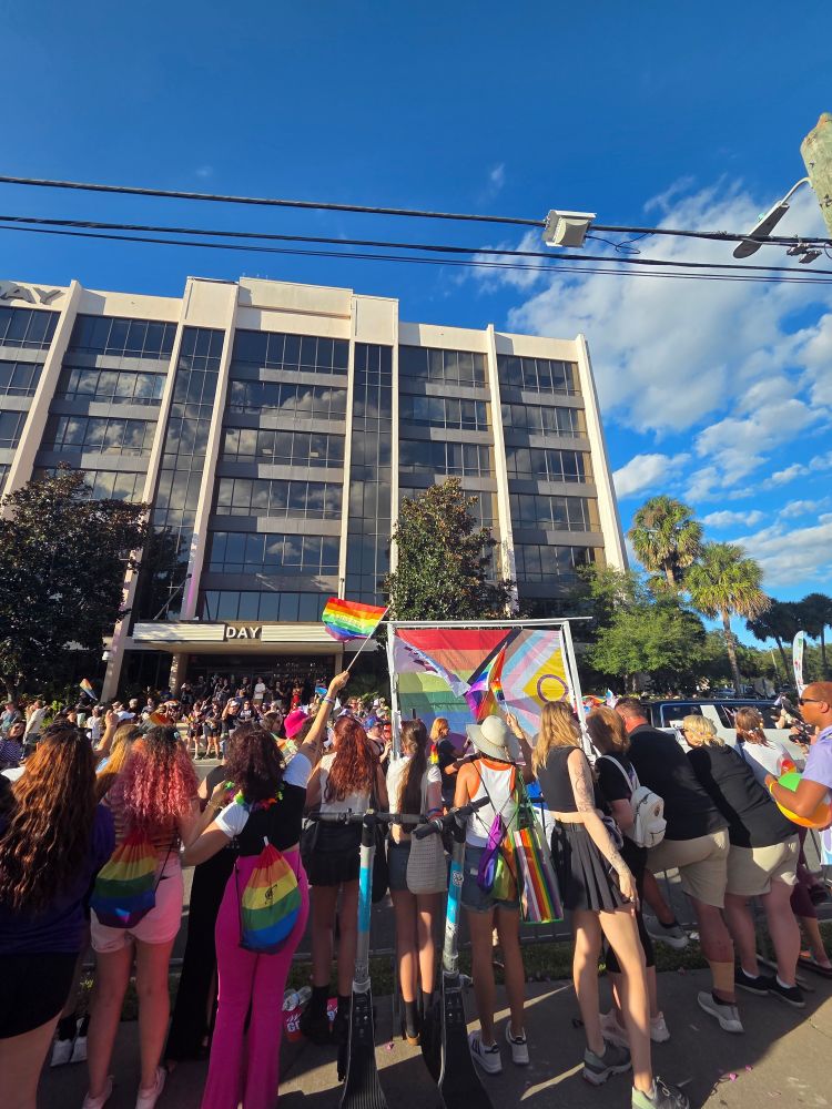 A bunch of gay people waving a flag at pride