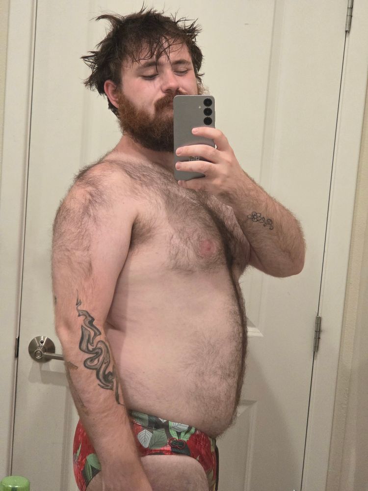 Myself, freshly out of the shower with a speedo on that shows a red and green floral design. My hair's messy.