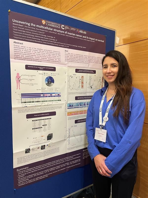 Postdoc Shimrit Mayer stands in front of her scientific poster showcasing her research project at the ESSB conference