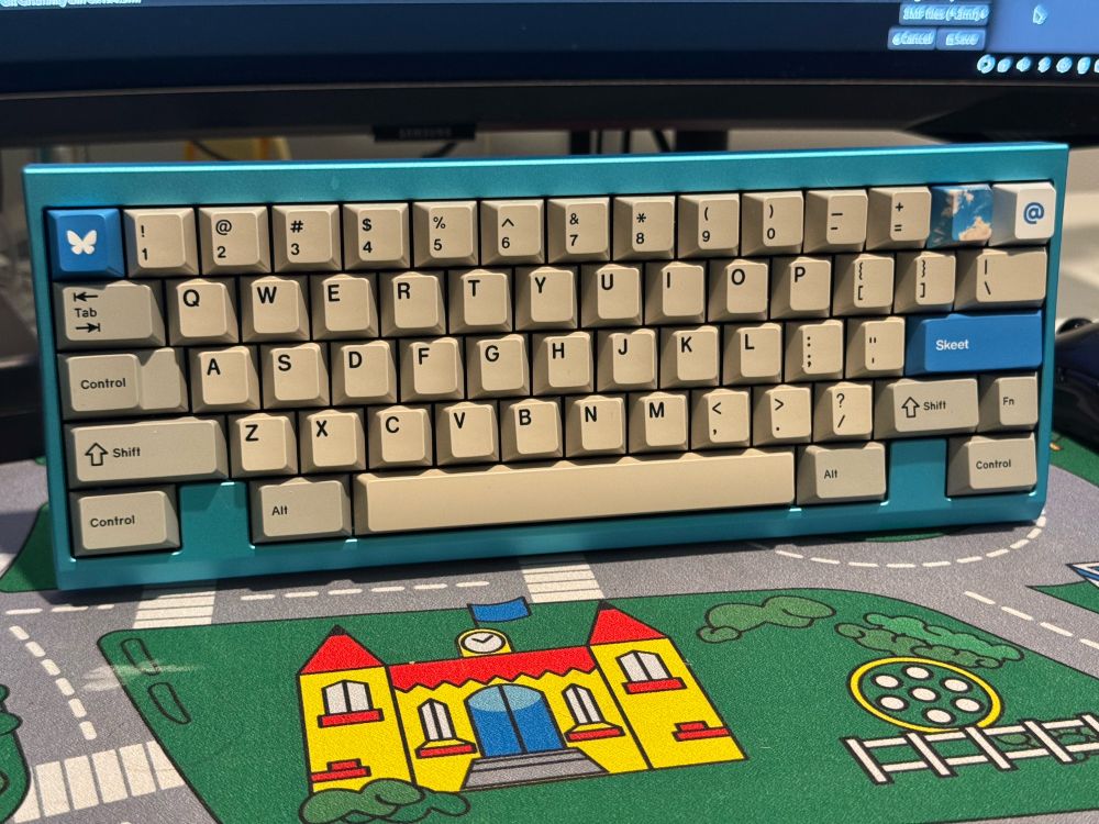 A mechanical keyboard on a stand with beige key caps and novelty bluesky keycaps