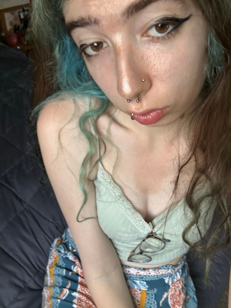 maeve in her natural habitat wearing makeup and a mint green top and blue+red+orange pants