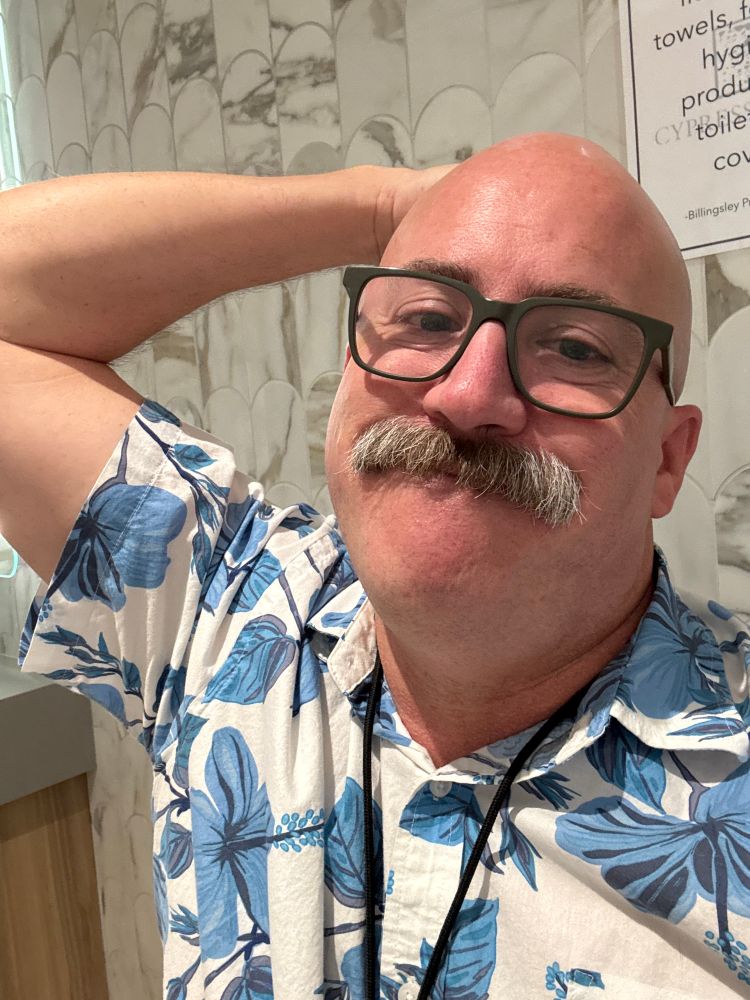Some asshole in the bathroom making “bear face”
Greying mustache. Loud blue and white Hawaiian shirt. Glasses.