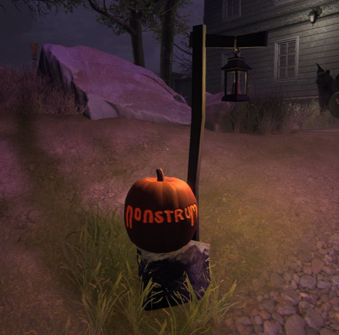 The reverse of our Brute pumpkin, with 'Monstrum' carved across the back. A large rock and dark grey house loom in the background.