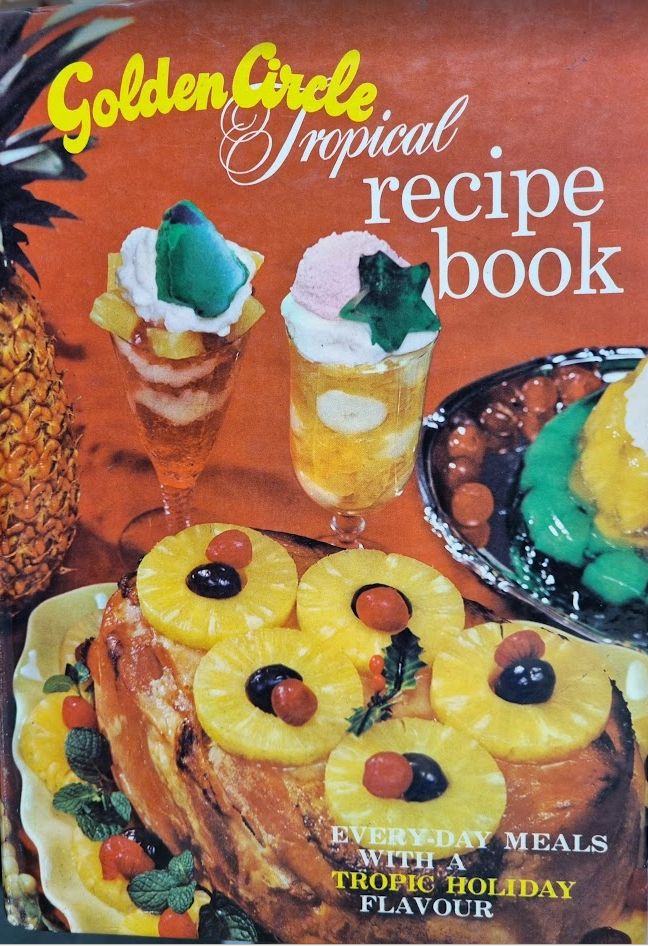 Front cover of old retro (late 70's - early 80's?) Cookbook "Golden Circle Tropical Recipe Book" with photo of various dishes that feature pineapple as key ingredient.