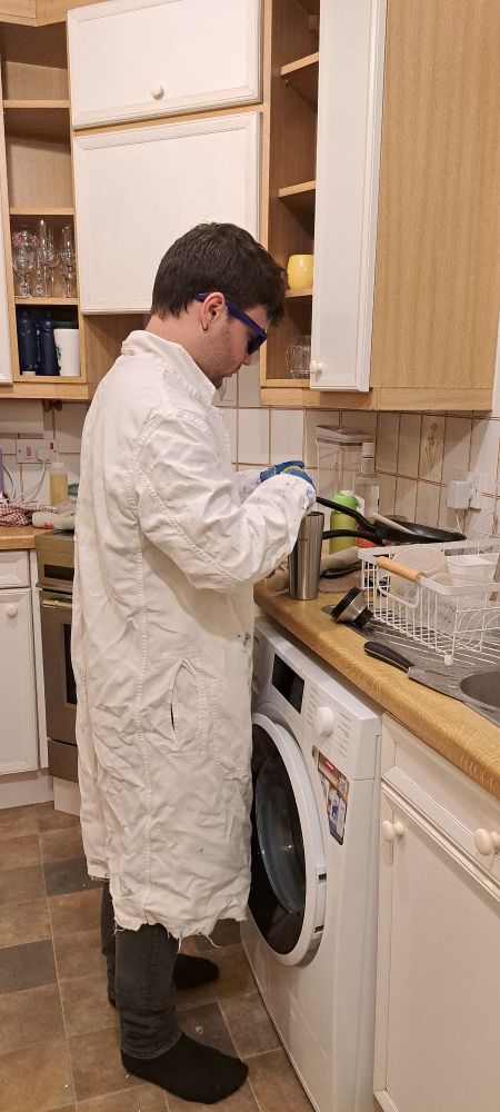 My son wearing a labcoat in the kitchen while making cocktails. 