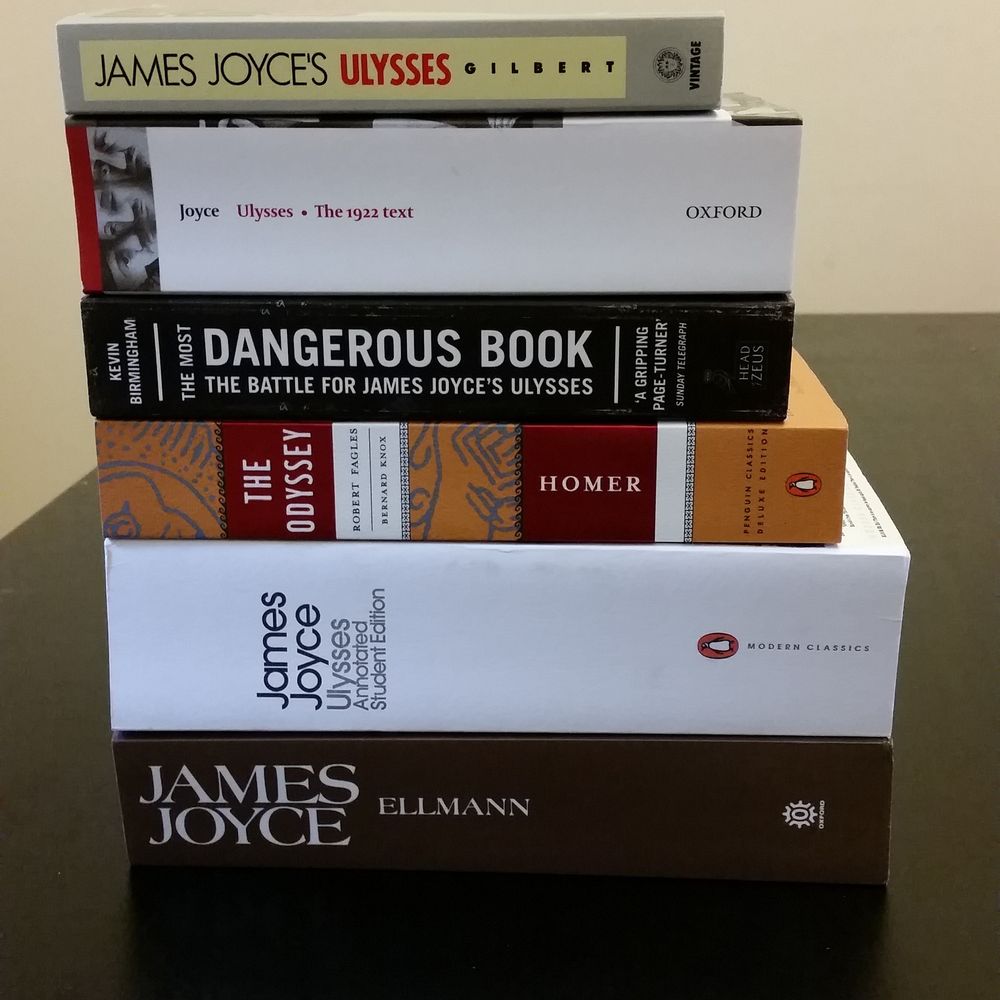 A pile of 6 books all related to the book Ulysses by James Joyce. They are

- Ulysses by James Joyce
- Ulysses the 1922 text
- The most dangerous book by Kevin Birmingham
- The Odyssey by Homer
- Ulysses the annotated student edition
- James Joyce by Ellman
