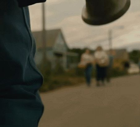 a blurry picture of people walking down a street with houses in the background