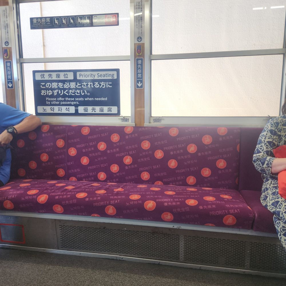 京福電鉄車内。優先座席の座面に四ヶ国語でその旨が印字されているのが分かりやすい