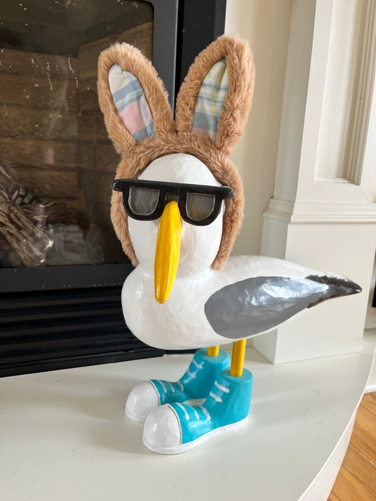 Painted seagull statue wearing bunny ears