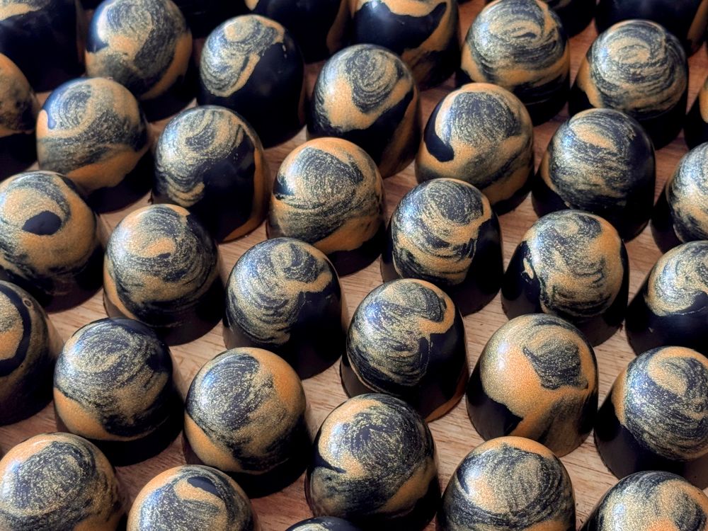 Rows and rows of gold and black chocolate domes.